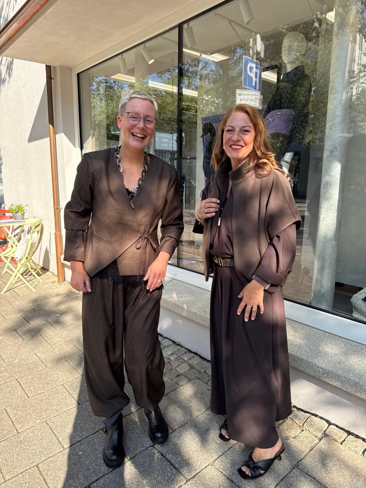 Zwei Modeberaterinnen von mittendrin vor dem Schaufenster